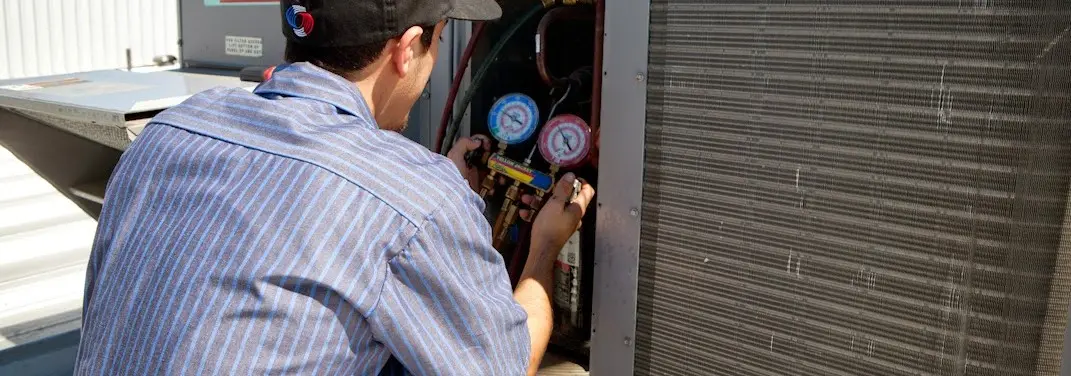 HVAC technician servicing a condenser unit in Dardenne Prairie
