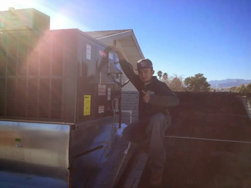 HVAC technician performing AC Tune-Up on a rooftop unit in Dardenne Prairie
